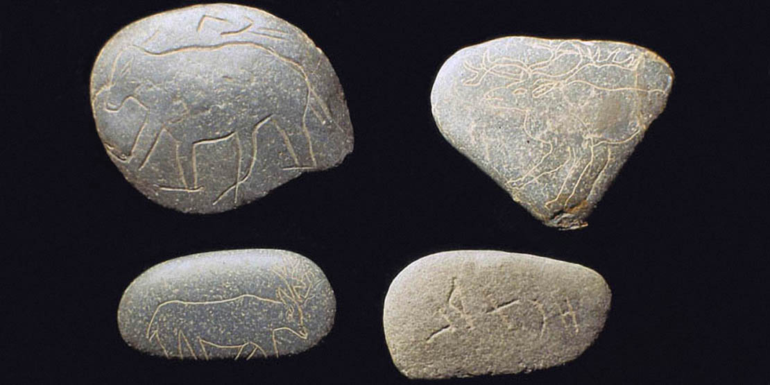 Quatre galets gravés : un ours (?) avec trois signes alphabétiformes ; quatre signes ;<br> gravure frustre d’un petit cervidé ; l’avant-train d’un cervidé
